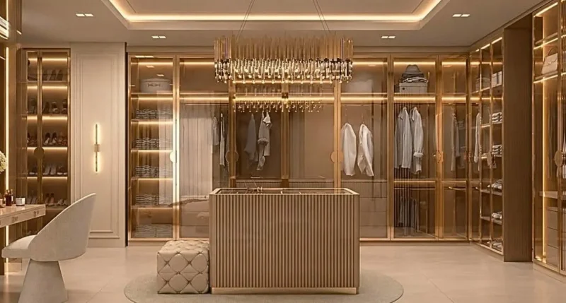 Closet da suíte master com armários de vidro, ilha central ripada e lustre de cristal — projeto residencial Suíte master, Michelle Rigopoulos